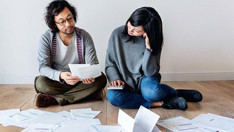 couple en désarroi devant un amoncellement de factures